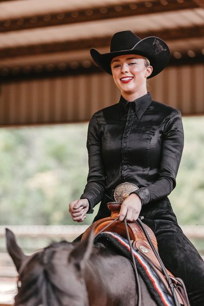 A NCEA college equestrian team rider smiles during western horsemanship.