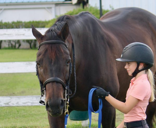 A young equestrian displaying the wrong way to hold a line.