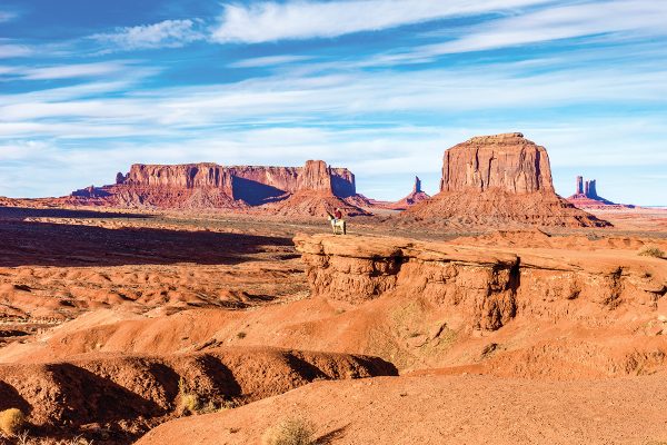 A man on a horse on the edge of Monument Valley