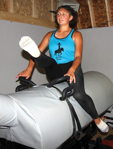 A vaulter practices vaulting exercises on a stationary barrel