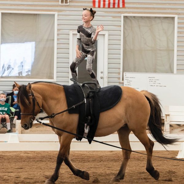 A young equestrian competing in vaulting