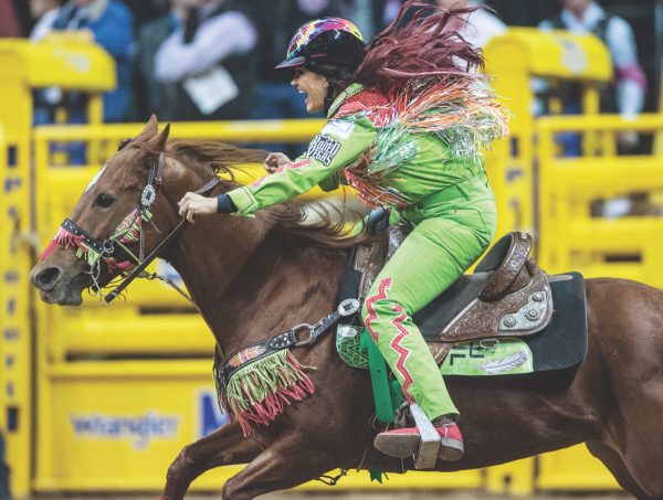 Fallon Taylor barrel racing in one of her bright outfits