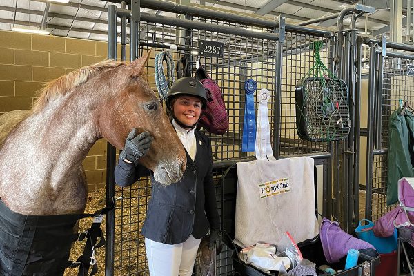 A young equestrian at a horse show with all the items she packed